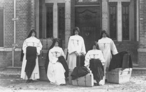 Levensverhalen van religieuzen. 'Witte Zusters' poseren buiten voor het klooster met hun koffers, klaar om naar Afrika te vertrekken. 